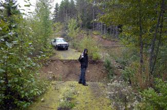 Geoff looking at the wide washout that stopped the truck from reaching the end of the road